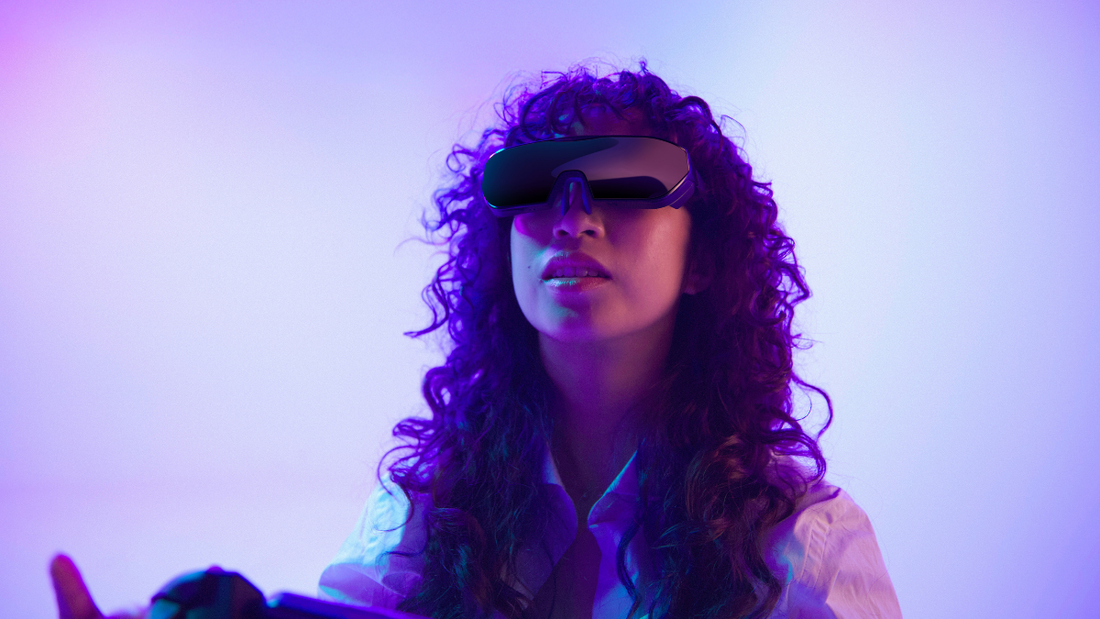Gamer wearing Sentinel XR Glasses, fully immersed in a vibrant purple gaming environment